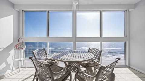 Edgewater West 95 - Bright sunroom featuring a table for four and beautiful Gulf views, perfect for meals or quiet moments.