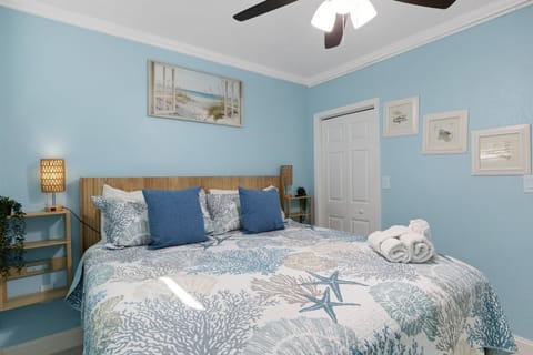 Primary Bedroom: A serene sanctuary featuring a King-sized bed, smart TV and a ceiling fan.