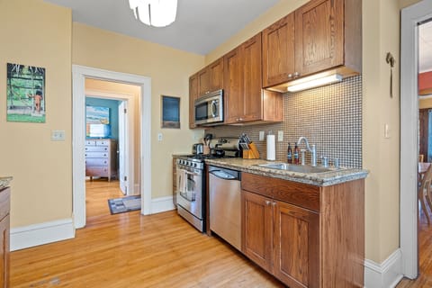 Your fully equipped kitchen features warm wood cabinets, granite counters, and stainless appliances—perfect for preparing meals during your stay.