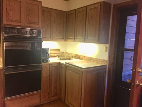 Kitchen includes two ovens, under-counter lighting, & access to the back deck.