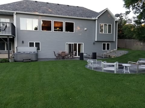 Fire pit, hot tub, deck, swing set, and huge patio in the fenced back yard.