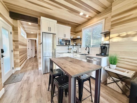 The modern kitchen has all of the conveniences you need to prepare your favorite dishes, including a large fridge, stovetop, convection microwave oven, coffee station, farmhouse sink and a dining table for 4.