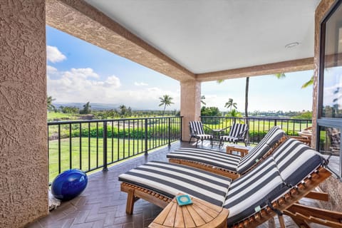 Unwind on your private balcony with striped loungers overlooking lush golf course greens and swaying palms.