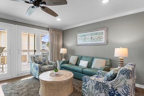 Unwind in your coastal-themed living room with plush seating and serene ocean artwork creating the perfect vacation atmosphere.