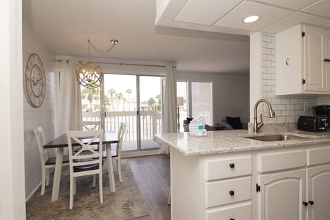Your bright, open kitchen flows seamlessly into the dining area, where you can enjoy morning coffee while palm trees sway outside your balcony doors.