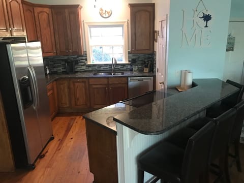 Open kitchen area where all can gather with stainless appliances. 