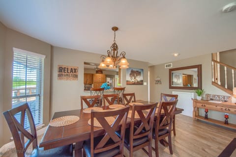 The dining area has a large table with seating for 8 and 2 bar stools at the breakfast bar.