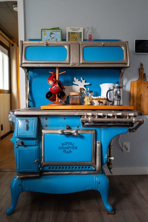 Coffee & tea bar with cream, sugar, frother, French press & kettle — all perched on a 1900s cooking stove (but don't worry we have a modern one for you too!)