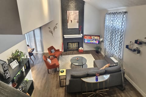 Living room with vaulted ceiling has a wall mounted 4K 50inch smart TV. 