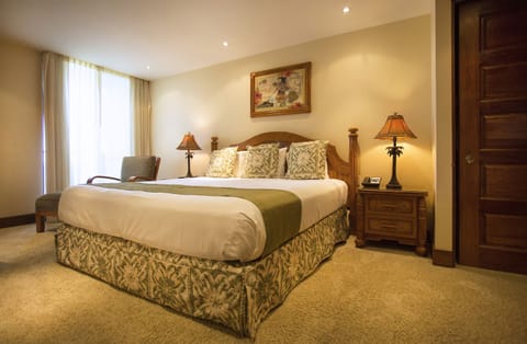 Sink into the plush king bed where tropical-themed lamps cast a warm glow and elegant furnishings invite you to truly unwind in comfort.