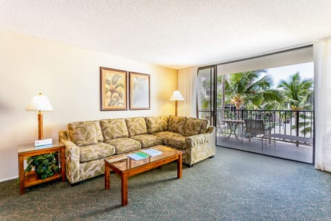 Sink into your cozy tropical retreat where palm trees sway beyond your private balcony and island breezes drift through the open doors, inviting relaxation at every turn.