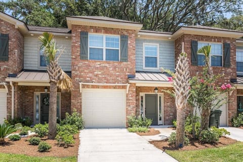 Property exterior with brick facade, garage, and palm trees