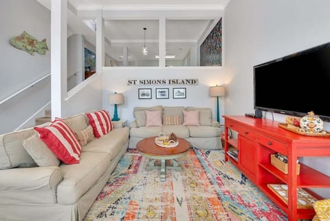Bright living room with red accents and colorful rug