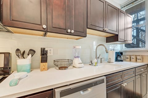 Glass tile surrounds this custom kitchen with a pull down faucet.