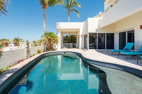 Indoor-Outdoor Living Flow: Step effortlessly from the living space to the pool deck through multiple sets of large sliding glass doors, creating a seamless open-concept connection between the private interior and the luxurious pool and outdoor living are