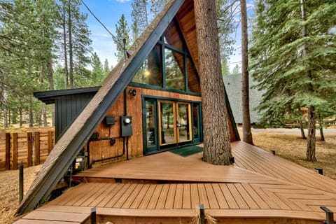 Charming A-frame cabin nestled among towering pines with spacious deck and forest views.