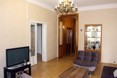 A spacious sitting room, with a  TV, couch, armchairs, cocktail table.