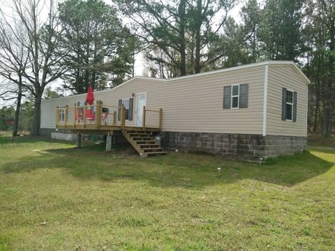 Large front deck with charcoal grill, table, and chairs