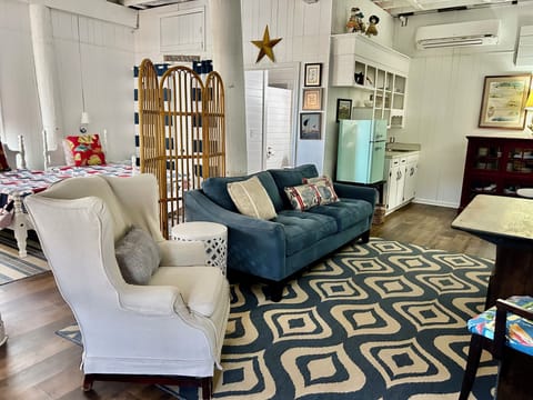 TV lounge area with small refrigerator, sink and coffee maker.