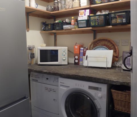Utility room with fridge/freezer, washer, drier, microwave. Sharing essentials.