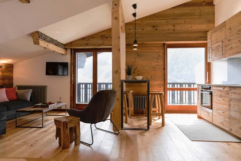 Open plan living area with 2 sets of glass doors onto balcony