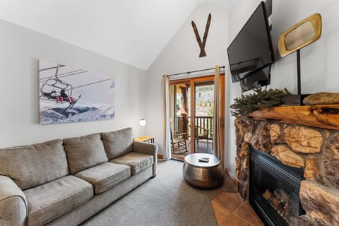 Unwind in your cozy mountain retreat with rustic stone fireplace and private balcony perfect for après-ski relaxation.