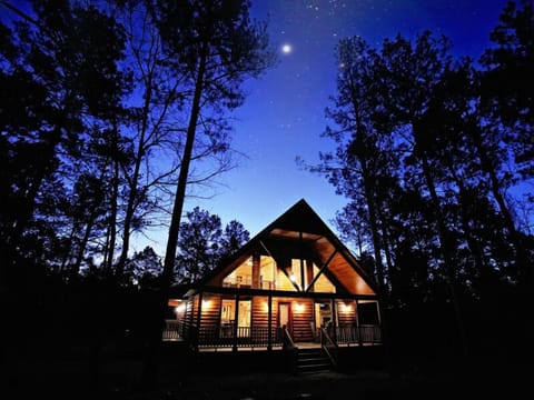Experience the magic of the cabin at night, beautifully lit beneath a peaceful, star-filled sky.
