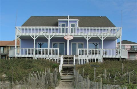 Charming beachfront house with wraparound decks and direct beach access via private walkway.