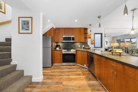 Fully equipped kitchen with wooden cabinetry, modern appliances, and open layout for easy meal prep.