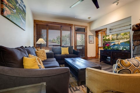 Sink into plush sectional seating with colorful pillows while your favorite shows play on the large TV in this cozy mountain retreat.
