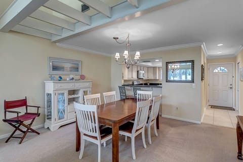 - Gather at this welcoming dining table set for six, perfectly positioned between the front door and kitchen
- Natural light, soft carpet, and classic lighting create a cozy place to dine
- Decor touches and layout make this the heart of the home