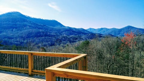 Covered deck has wrought iron/wicker furniture for relaxing or enjoying a meal