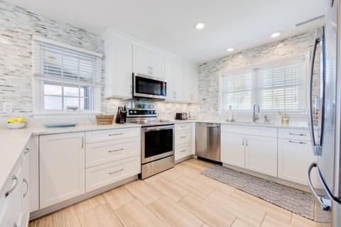 Step into your fully-equipped kitchen, where white cabinetry and modern appliances create an inviting space for preparing delicious vacation meals together.