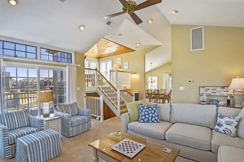 Picture yourself unwinding in this bright, spacious living area where vaulted ceilings and sunlight create an airy retreat for your coastal getaway.
