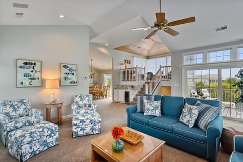 Sink into plush seating under soaring vaulted ceilings and let the ocean breeze drift in through oversized windows. Your coastal retreat awaits, blending comfort with breezy elegance.