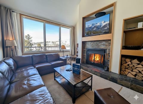 Cozy up on plush leather seating by your crackling fireplace, watching snowy mountain views through expansive windows after your alpine adventures.