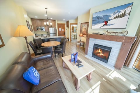 Unwind in your cozy living space where warm flames dance in the fireplace while you relax on plush leather seating after mountain adventures.