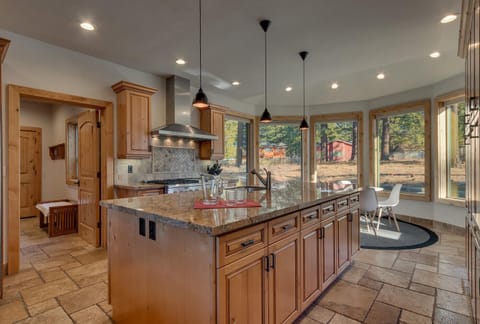 - Kitchen island with granite counters and seating for casual meals  
- Large windows bring in natural light and scenic forest views  
- Fully stocked space designed for cooking and conversation