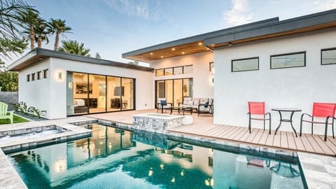 Luxurious outdoor living with pool, fire pit & lush tropical ambiance.
