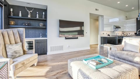 Spacious living room with high ceiling, modern décor & seamless kitchen flow.
