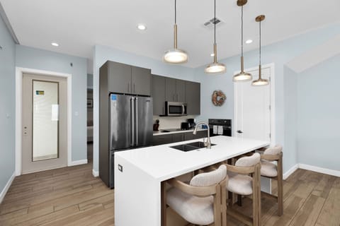 Fully stocked kitchen equipped with stainless steel appliances and a large center island