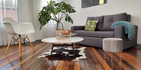 Chic living room with design pieces, antique wood floors & bright artistic vibe