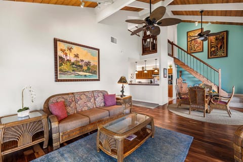 Charming living area with tropical accents and comfortable seating under vaulted ceilings.