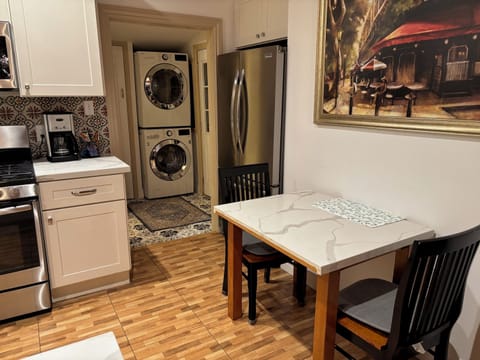 Kitchen area with small dinning table with 2 chairs, refrigerator, washer, dryer