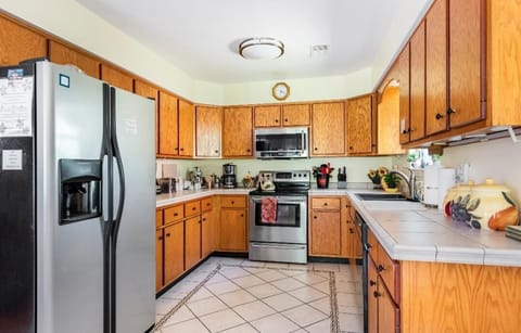 Long view LARGE Kitchen shows generous counter space and appliances, tiled floor