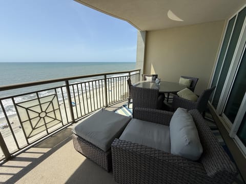 Oceanfront balcony with cozy seating and stunning views