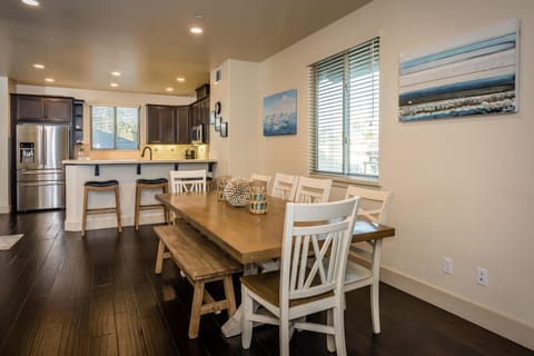 Dining for 8 plus nearby bar stools at the kitchen counter.