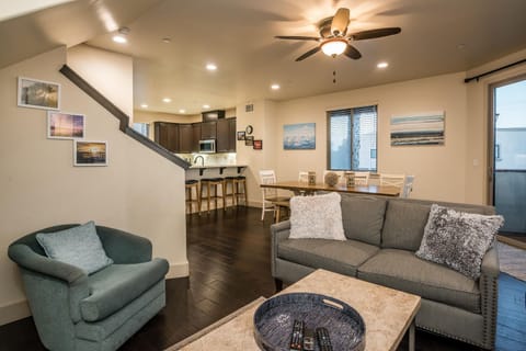 Living room, dining area and kitchen open space for friends and family to gather. Nearby is a sliding door leading to a balcony.