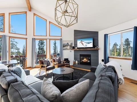 Upstairs Great Room —  With stunning windows that showcase the trees and mountains beyond. Snuggle up around the gas fireplace, take in a movie or watch the sunrise form this cozy space. 🏔✨