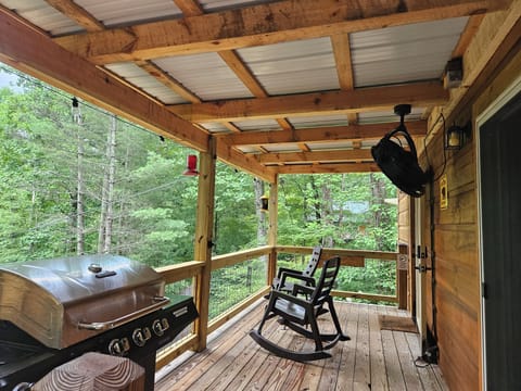 New covered deck with grill, rocking chairs, and fan.